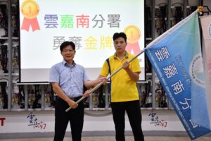 通傳-雲嘉南分署長劉邦棟(左)授旗代表選手李振程，期待選手們都能在「第56屆全國技能競賽」獲取佳績