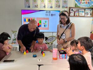 祖孫一同挑戰桌遊「快手疊杯」，在歡笑與互動之中增進情感交流，體現高齡暨失智友善活動「共讀、共感、共融」的精神。
